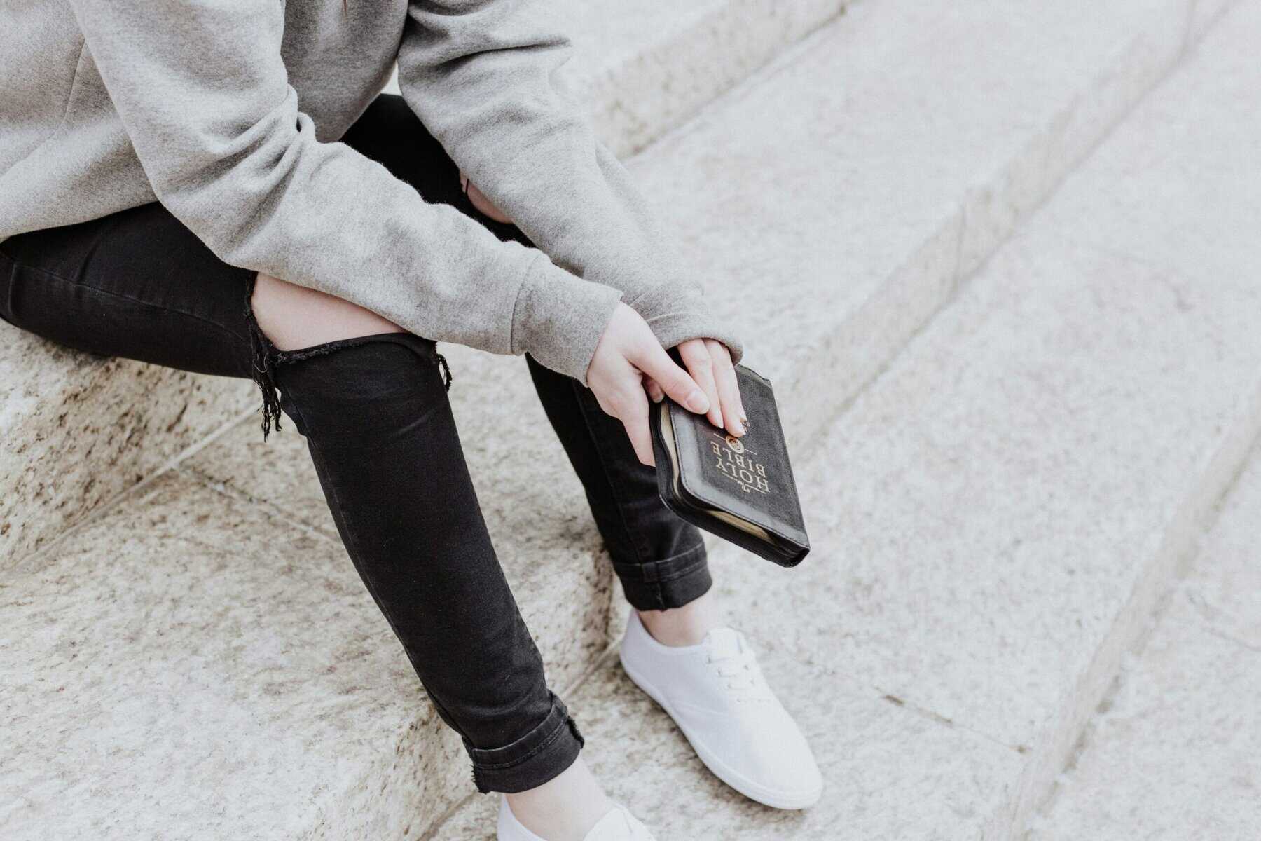 faceless person holding the Bible
