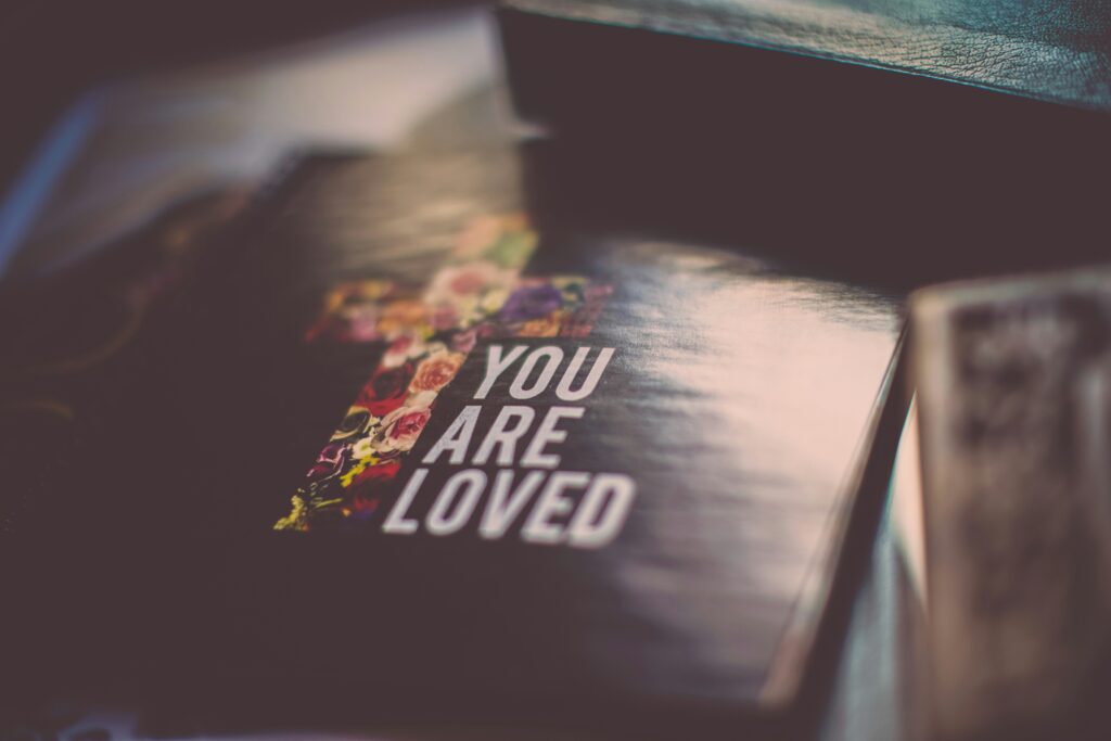 Bible with "you are loved" written atop.